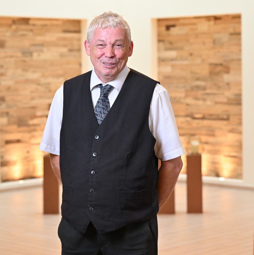 Mann mit Hemd und schwarzer Veste