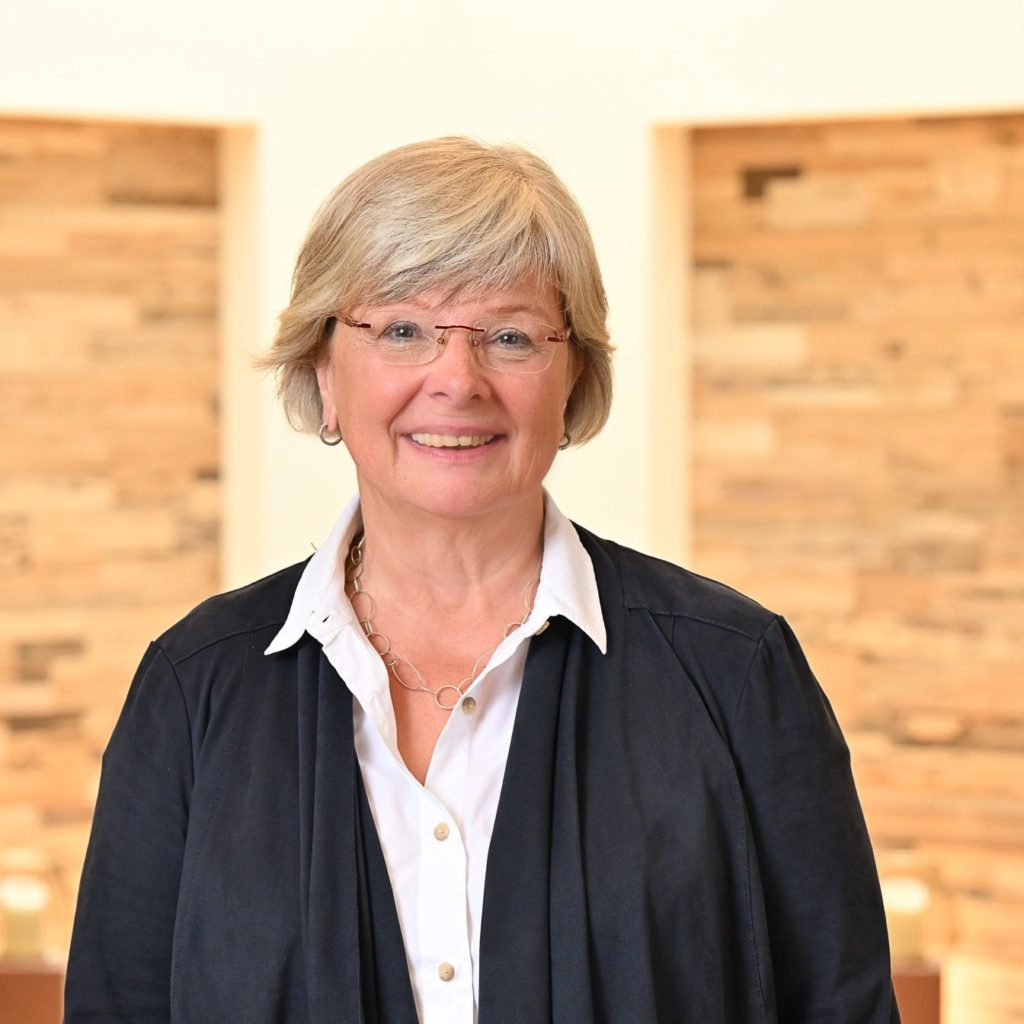 Frau mit blonden Haaren und weißer Bluse Porträt